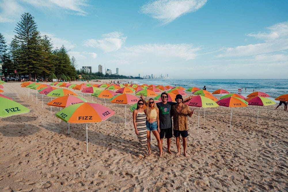 Taking over Burleigh, Fisher hands out 100 Hard Fizz Umbrellas Gold